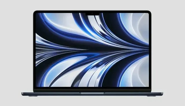 Un ordinateur portable bleu foncé est ouvert, affichant des motifs abstraits bleus et blancs sur son écran. L'arrière-plan est gris clair.