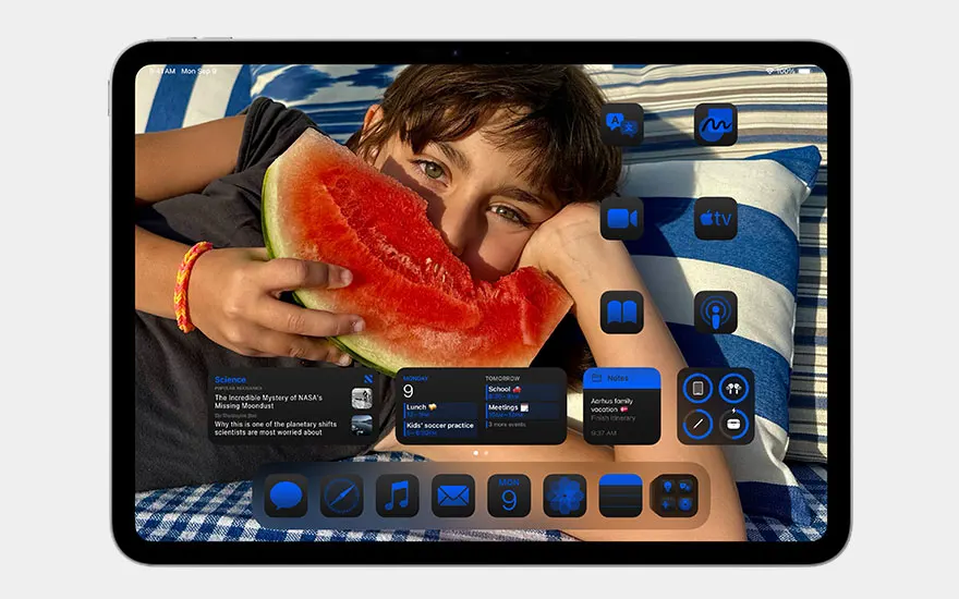 iPad home screen featuring lad eating watermelon. Widgets and applications organised on colourful desktop with personal touches.