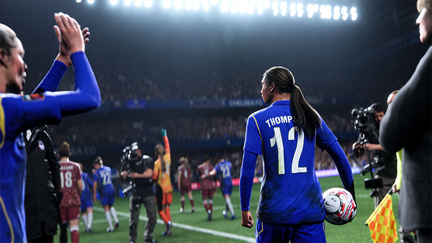 Een vrouwelijke voetballer met rugnummer 12 loopt met een bal langs de zijlijn in een verlicht stadion.