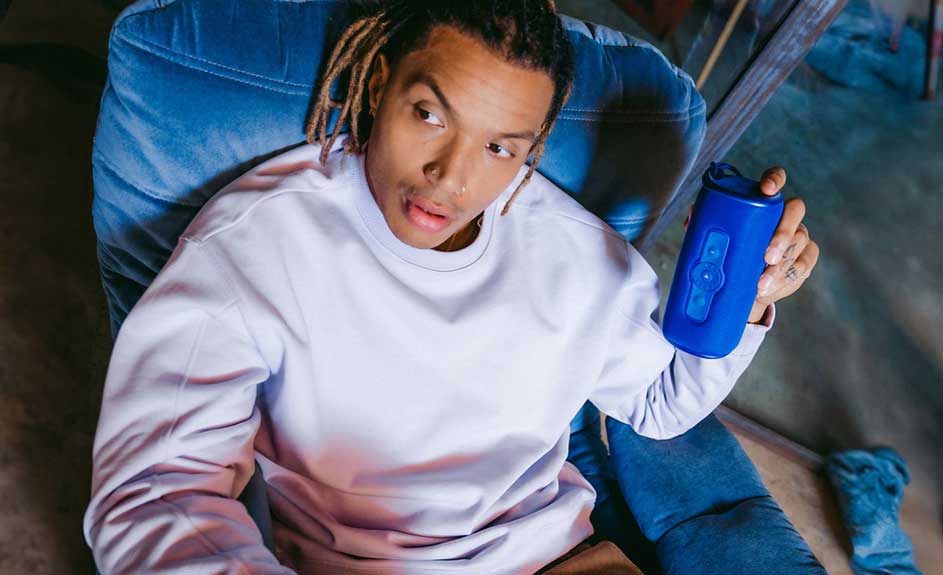 Een blauwe stoel met een blauwe waterfles in een hand, en een witte trui.