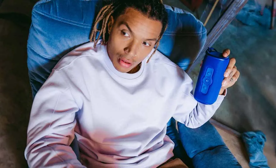 Een blauwe stoel met een blauwe waterfles in een hand, en een witte trui.