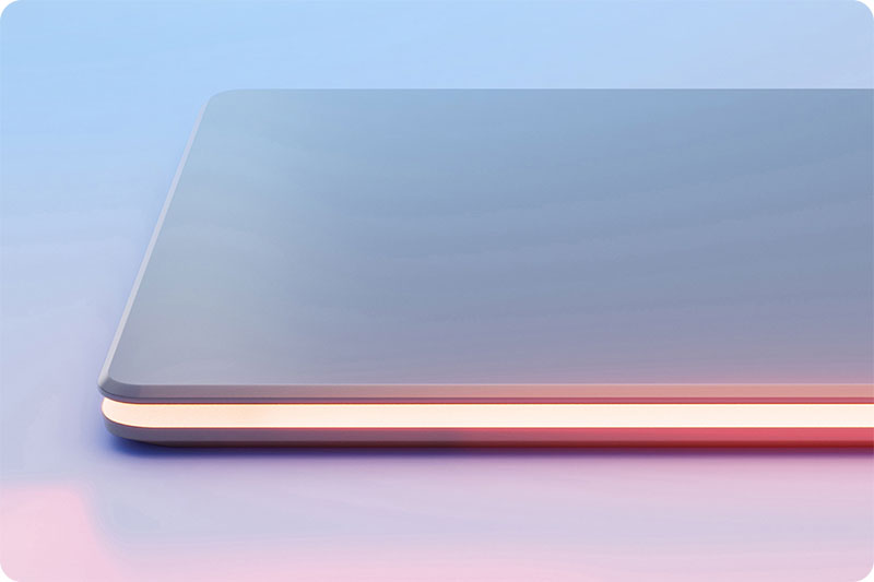 Une tablette grise est posée sur une surface bleue et rose, avec une bande lumineuse orange sur le bord.