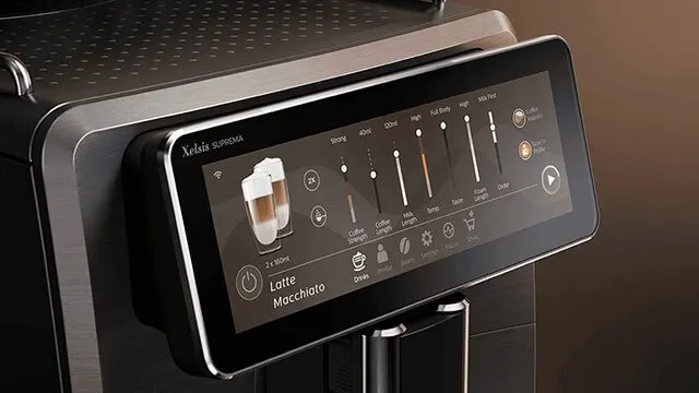 Gros plan d'une machine à café noire avec écran tactile affichant les options de réglage pour un latte macchiato.