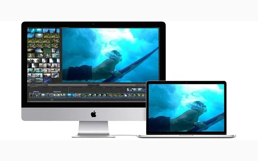 A silver desktop and laptop display a blue underwater scene on a white background. The desktop screen also shows a video editing timeline.