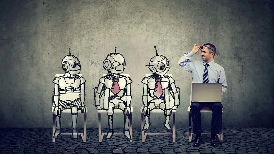 Trois robots dessinés et un homme assis avec un ordinateur portable devant un mur gris.