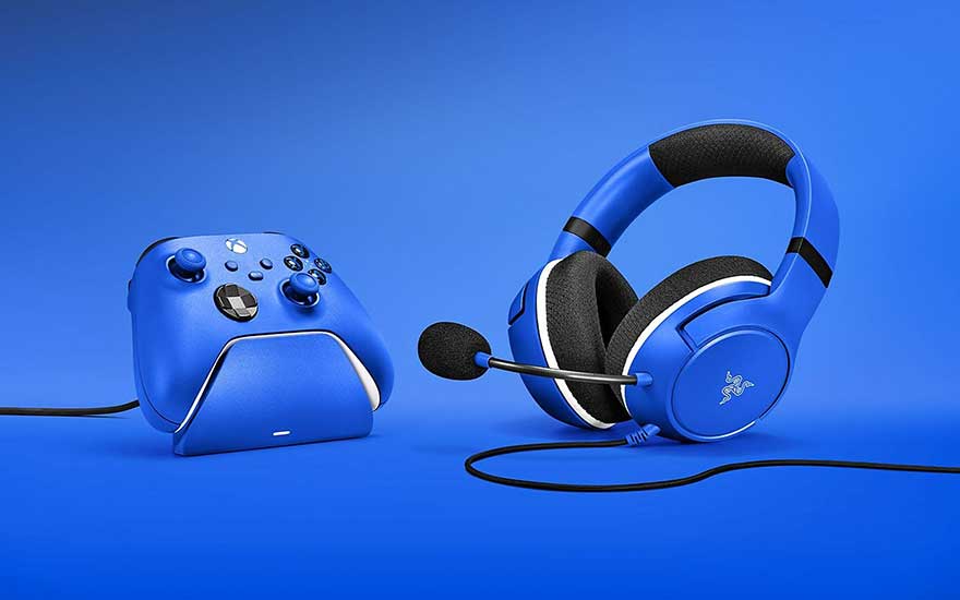 Un casque bleu avec microphone et une manette Xbox bleue sur fond bleu.
