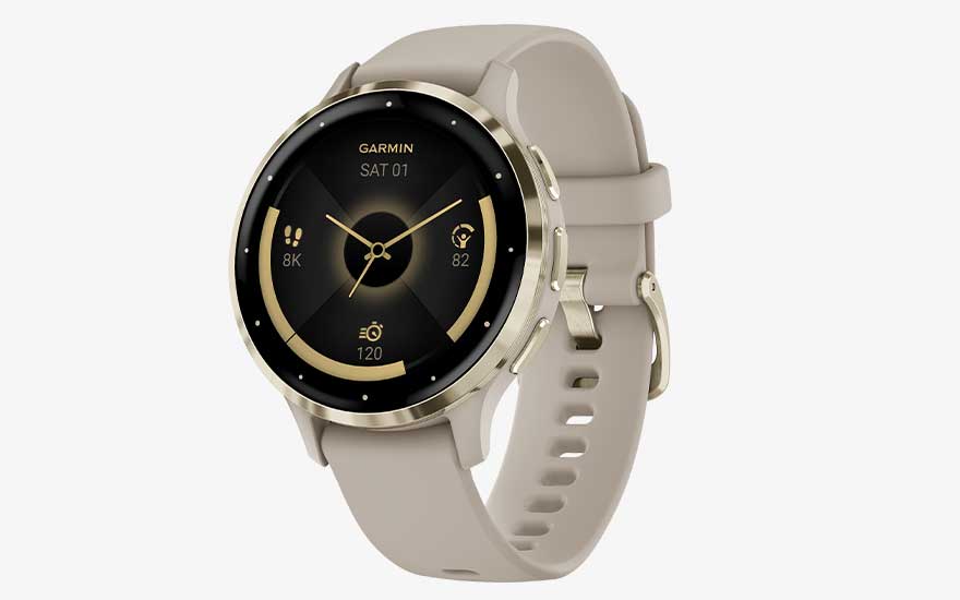 Een elegante Garmin-smartwatch met beige band toont de tijd, het aantal stappen, de hartslag en andere gezondheidsgegevens.