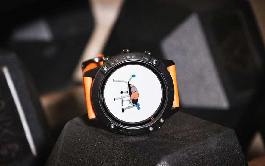 Une montre de sport noire et orange affiche un dessin d'exercice sur un écran blanc, sur fond noir.