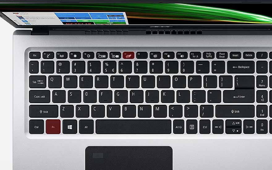 Zicht op een laptoptoetsenbord met zwarte toetsen en witte letters op een zilverkleurige achtergrond, gedeeltelijk zichtbaar scherm.