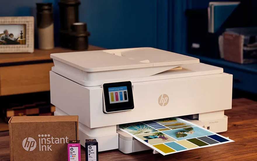 Een witte HP-printer met Instant Ink drukt kleurrijke foto’s af. Op tafel staan de printer, inktpatronen en de bijbehorende verpakking.
