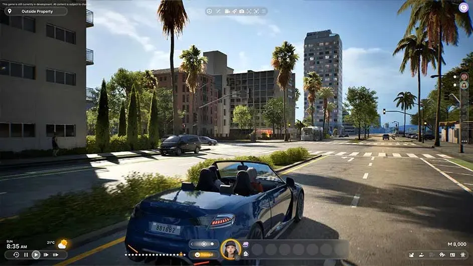 Une voiture bleue roule sur une route urbaine bordée de palmiers et d'immeubles sous un ciel clair.