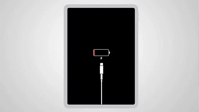 Écran noir d'une tablette affichant une icône de batterie faible et un câble de charge blanc sur fond blanc.