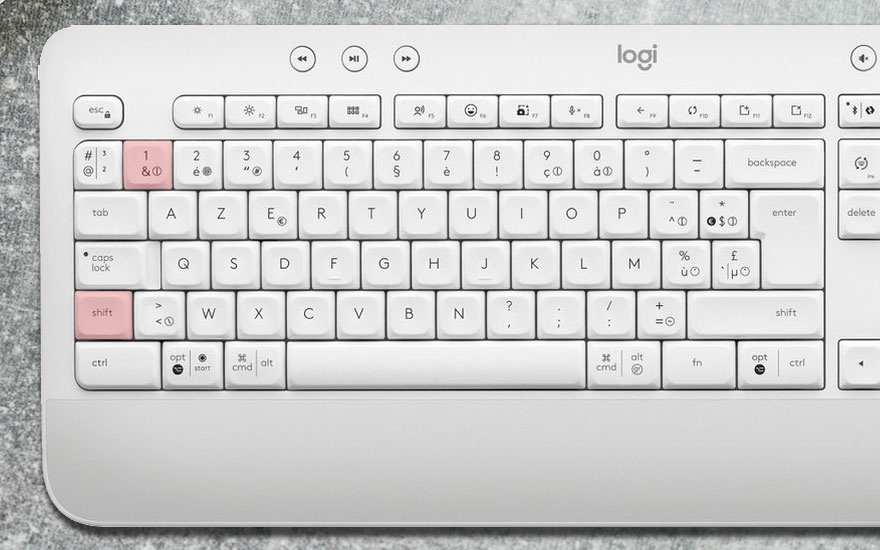 Clavier blanc Logi avec touches AZERTY. Les touches 1 et shift sont roses. Le fond est gris.