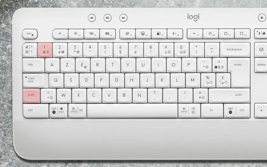 Clavier blanc Logi avec touches AZERTY. Les touches 1 et shift sont roses. Le fond est gris.