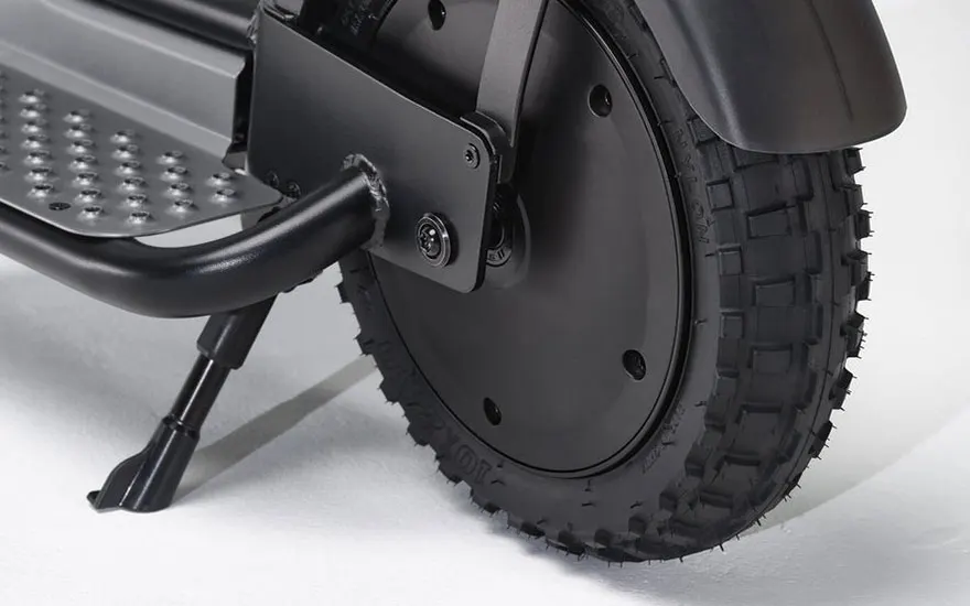 Detail van een robuuste, grof geprofileerde band en stevige achterconstructie, klaar voor hobbelige wegen en offroad ritten.