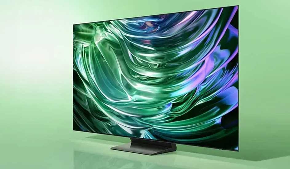 Een moderne televisie met ultradun zwart frame staat op een brede voet en toont een abstract patroon van groene en paarse golven op het scherm.