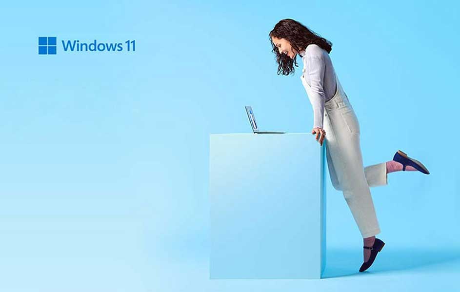 Logo Windows 11 bleu sur fond bleu clair. Un ordinateur portable est sur un piédestal bleu.