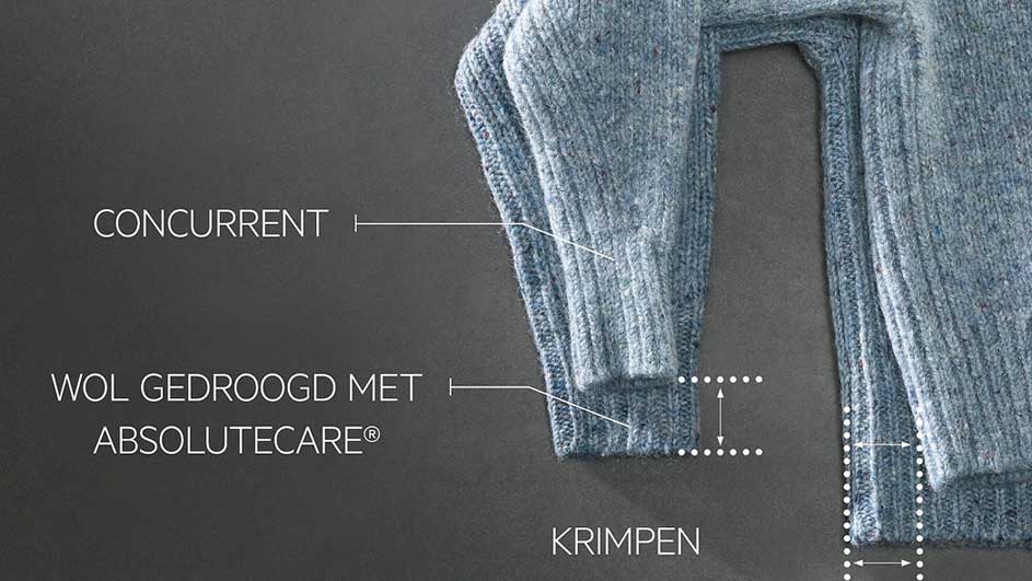 Detailopname van een blauwe wollen trui met tekst die verwijst naar 'concurrent', 'krimpen' en 'wol gedroogd met Absolutecare'.