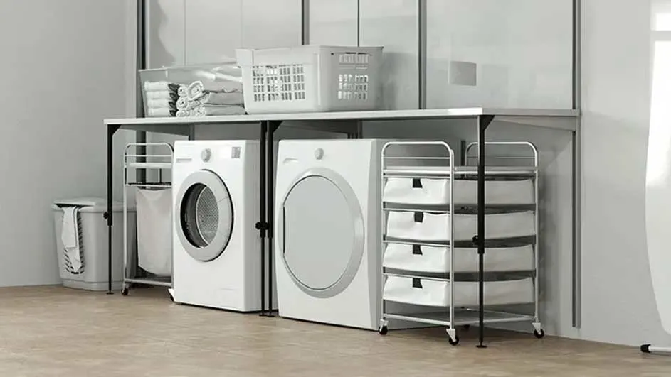 Wasmachine en droogkast staan onder een wit werkblad in een wasruimte met opbergmanden.