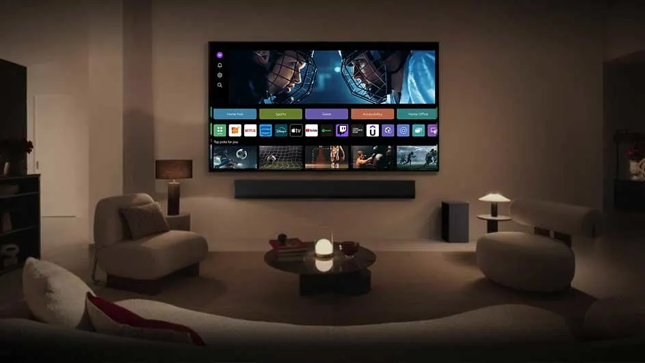 Woonkamer met grote tv aan de muur, soundbar, en zachte verlichting. Meubels omvatten een bank, stoelen, en een ronde tafel.