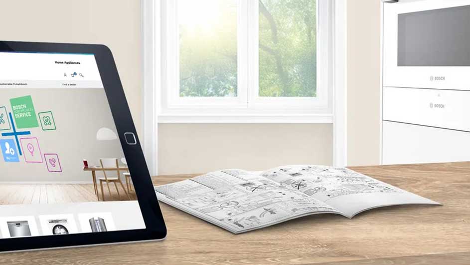 Tableau en bois avec tablette affichant un service Bosch, livre d'instructions ouvert et fenêtre.