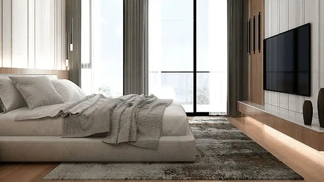 A bedroom features a bed with grey bedding, a large window with curtains, and a wall-mounted television.