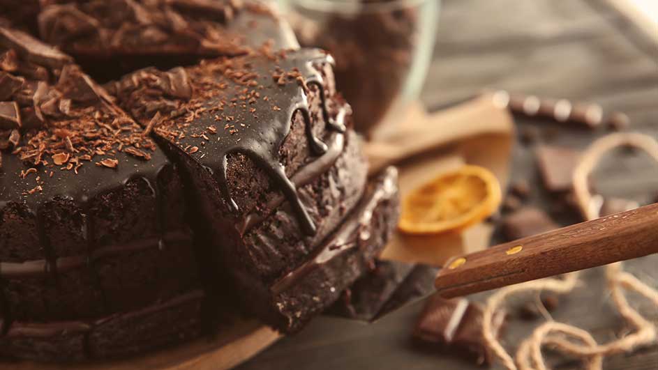 Pâtisseries au chocolat sur une planche à découper avec une tranche d'orange et un couteau.