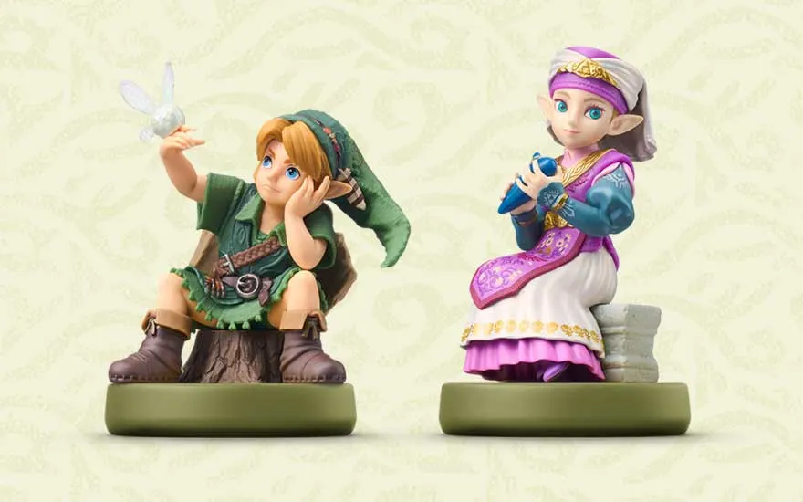 Deux figurines de collection sont côte à côte : Link est assis avec Navi sur une souche, tandis que Zelda tient une harpe bleue.