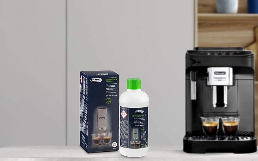 Une boîte et une bouteille de détartrant DeLonghi à côté d'une machine à café noire avec deux tasses de café.
