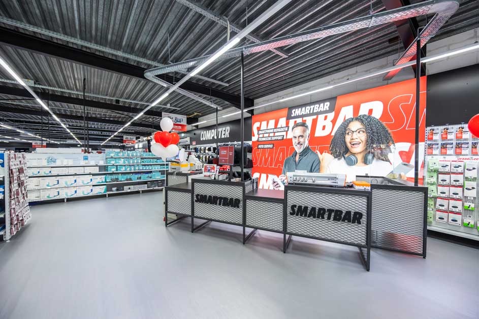 Interior of a store with the Smartbar desk in the foreground and shelves in the background.