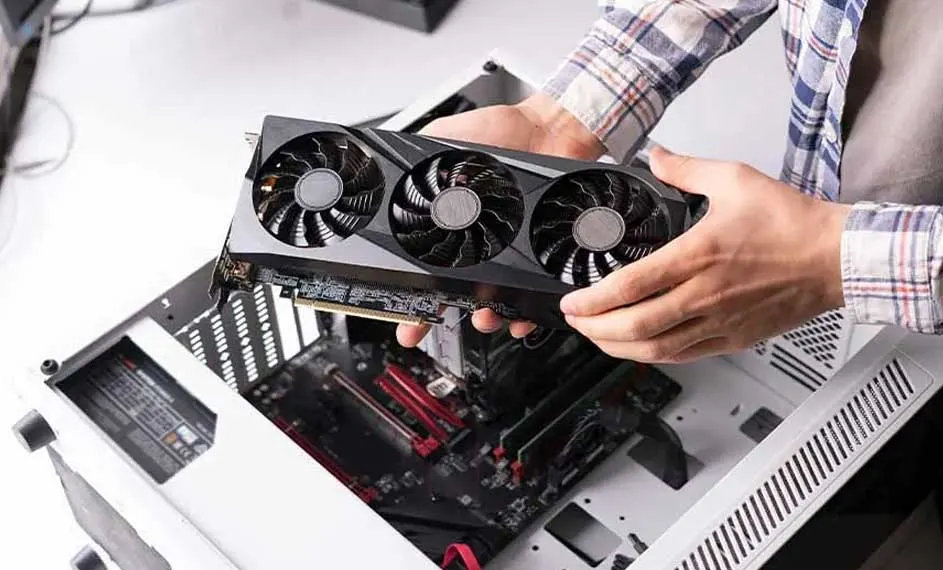 Een zwart grafische kaart met drie ventilatoren wordt boven een open computerbehuizing gehouden.