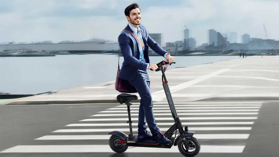 Een zwarte scooter met zitje staat op een zebrapad. Op de achtergrond is een rivier en een stad te zien.