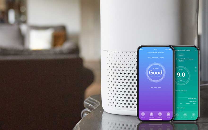 Un smartphone affichant une appli indiquant « Good » est posé près d’un purificateur blanc dans un intérieur chaleureux.