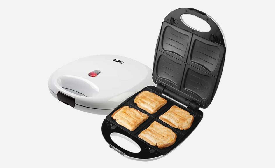 Een witte Domo tosti-ijzer, open met vier tosti's erin, en een gesloten apparaat op een witte achtergrond.