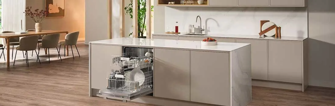 In een ruime, lichte keuken staat een vaatwasser open op het kookeiland, gevuld met servies in een moderne, gezellige eetruimte.