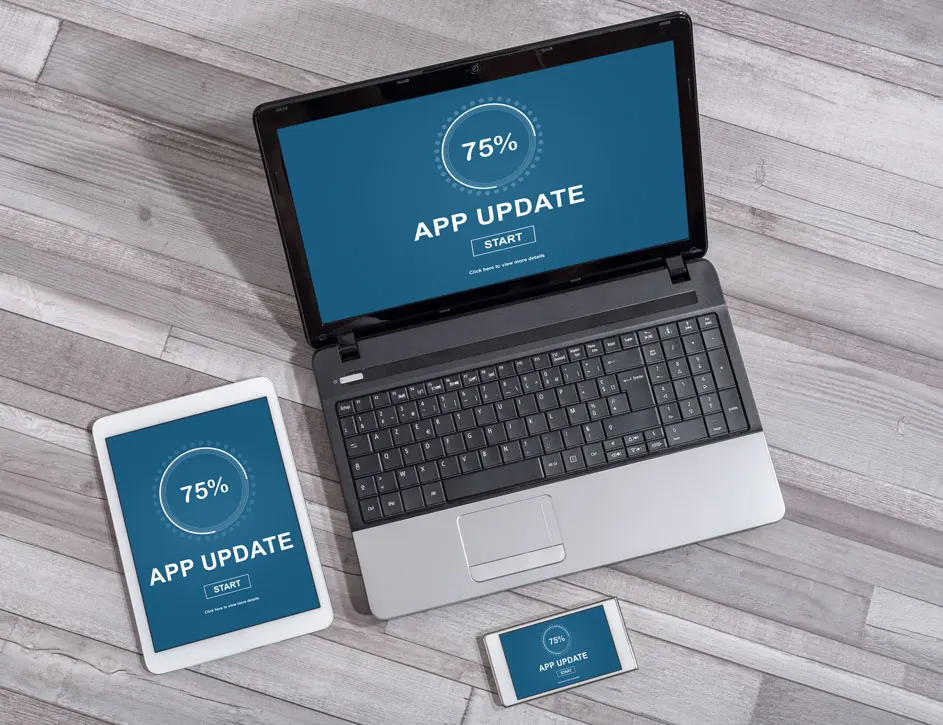 Laptop, tablet en smartphone tonen een app-update van 75% op een houten achtergrond.