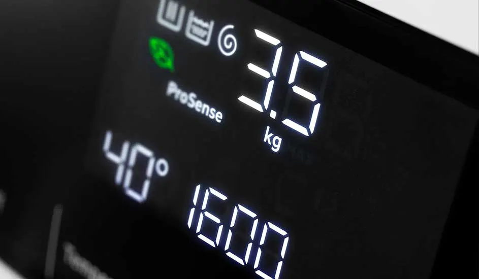 Écran noir avec des chiffres blancs indiquant 40 degrés, 3,5 kg et 1600.