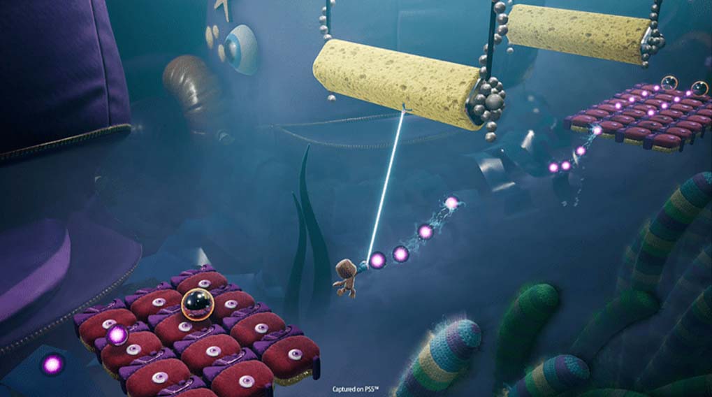 Un jeu vidéo sous-marin avec un personnage tirant un fil lumineux entre des plateformes et des éléments de décor colorés.