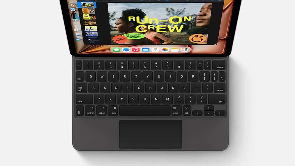 Een iPad met een zwart toetsenbord tegen een witte achtergrond. Het scherm toont een afbeelding met de tekst "RUN-ON CREW".