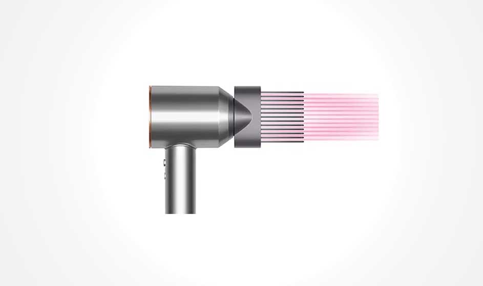 Un sèche-cheveux argenté avec un embout noir émettant des faisceaux de lumière rose sur un fond blanc.