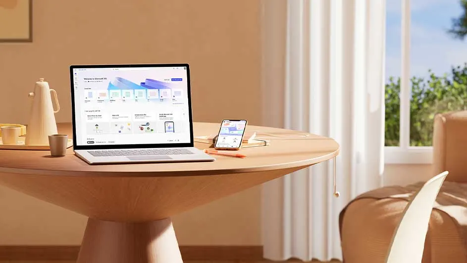 Table en bois avec ordinateur portable, smartphone, et tasse. Fenêtre avec rideaux blancs et végétation visible en arrière-plan.