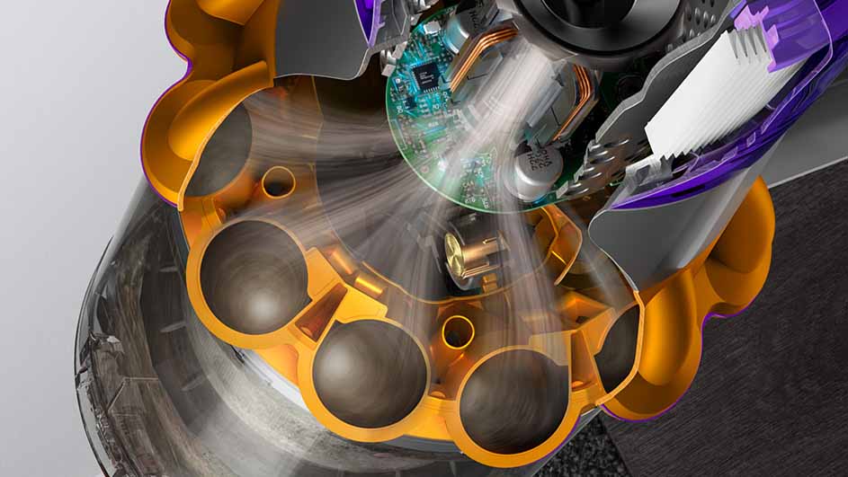 Gros plan de l'intérieur d'un aspirateur Dyson avec des composants jaune, violet, gris et une carte de circuit imprimé verte.