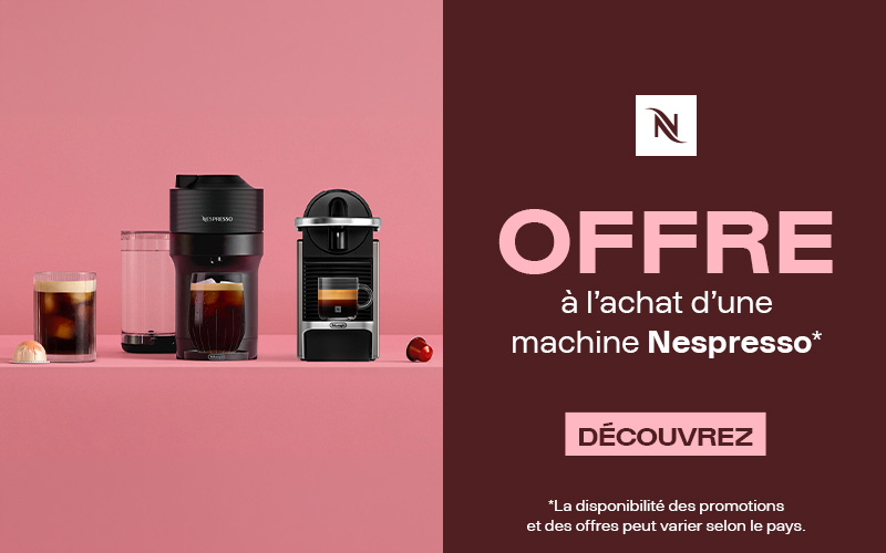 Deux machines à café Nespresso, des verres de café et des capsules sur fond rose, à côté d’un panneau promotionnel rouge foncé indiquant : « Offre à l’achat d’une machine Nespresso. Découvrez. »