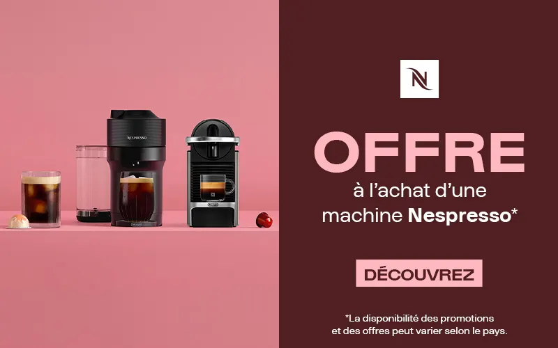 Deux machines à café Nespresso, des verres de café et des capsules sur fond rose, à côté d’un panneau promotionnel rouge foncé indiquant : « Offre à l’achat d’une machine Nespresso. Découvrez. »