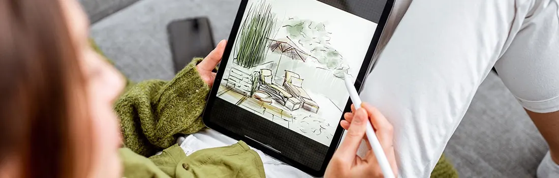 Tablet shows a drawing of chairs and plants. A white stylus rests on the tablet screen.