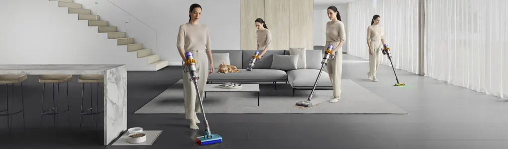 Un intérieur moderne, gris et blanc, avec un canapé, un tapis et des aspirateurs sans fil.
