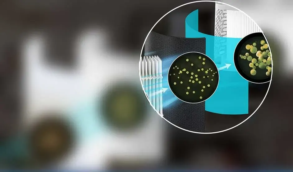 A blue airflow moves past several filters; in the zoomed circle many green particles are shown being captured and held inside the material.
