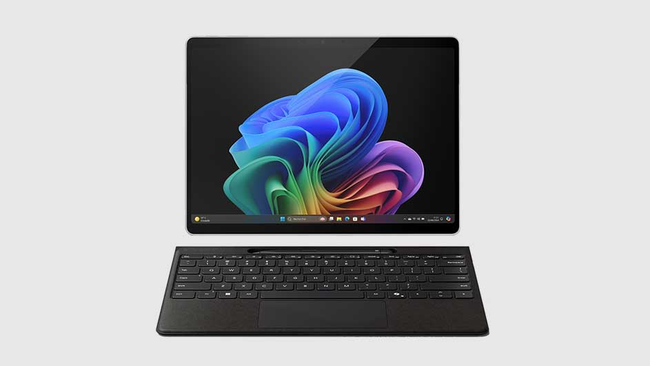 Een zwarte tablet met een kleurrijk bloemmotief op het scherm en een zwart toetsenbord op een witte achtergrond.