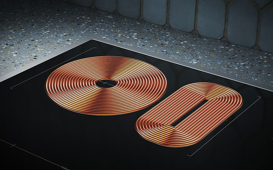 Een close-up van een zwarte inductiekookplaat met een ronde en ovale kookzone, beide gemaakt van koperkleurige spiralen.