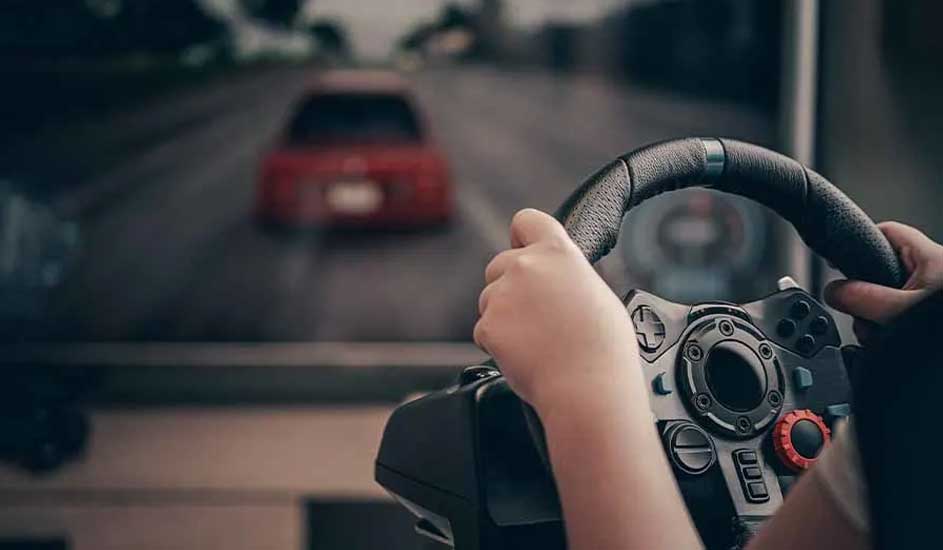 Mains tenant un volant de jeu noir avec un écran affichant une voiture rouge sur une route.